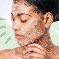 Frau mit Salz-Peeling im Gesicht und auf der Schulter. Ein sanftes mechanisches Peeling für reine Haut.
