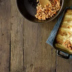 Préparation d'une recette cannelloni viande hachée et béchamel : viande cuisinée dans une poêle, cannelloni garni sur une spatule, plat gratiné au fromage.