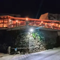 Restaurante Botavara San Jose, iluminado por la noche, con escaleras de piedra y una vista acogedora.