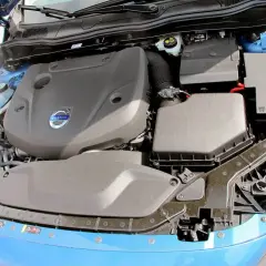 Motorutrymme på en blå Volvo V60. En kamremsbyte kan vara aktuell för att hålla motorn i toppskick.