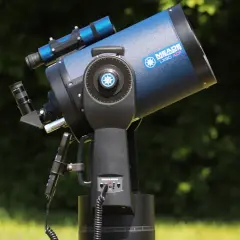 Niebieski teleskop Meade LX90 ACF na montażu, na tle zieleni.