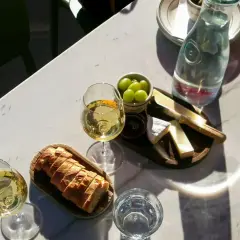 Dwa kieliszki białego wina, idealne do deski serów i pieczywa. Może to być orzeźwiające grenache wino.