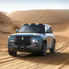 Niebieski SUV U8 przemierza piaszczyste wydmy, zostawiając ślady opon na pustyni.