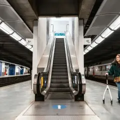 Kobieta z chodzikiem na peronie kolejowym, gotowa na podróże koleją.