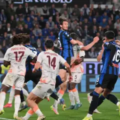 Piłkarze AS Roma i Atalanty walczą o piłkę w powietrzu. W akcji zawodnicy z numerami 17 i 14.