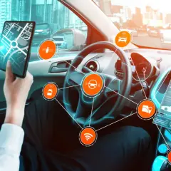 Wnętrze samochodu autonomicznego z interfejsem dsc, mapą na tablecie i ikonami technologii.