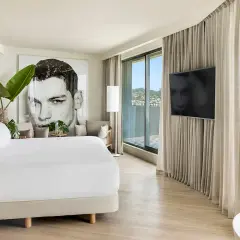 Habitación moderna en el hotel Terramar Sitges con cama king, arte de gran tamaño y vistas al mar.