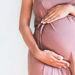 Kobieta w ciąży trzyma dłonie na brzuchu, zastanawiając się, ile się tyje w ciąży.