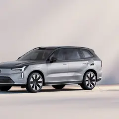 En silverfärgad elbil laddas vid en laddstation. Undrar du vad kostar en ny bil? Denna Volvo ser futuristisk ut.