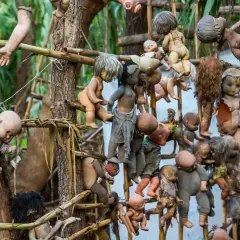 En la Isla de las Muñecas, muñecas viejas y rotas cuelgan de árboles y estructuras, creando una escena espeluznante.