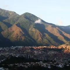 Góry otaczają Caracas, stolicę Wenezueli. Widać gęsto zabudowane wzgórza i nowoczesne budynki.