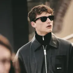 Joven con gafas de sol y chaqueta de cuero, luciendo modernos cortes de pelo hombre joven.
