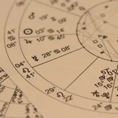 Zbliżenie na papier z wykresem astrologicznym, symbolami i liczbami. Może to być horoskop anielski na jutro.