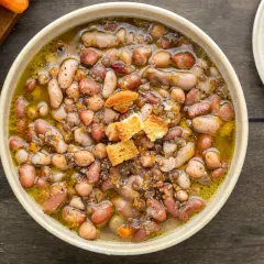 Una ciotola fumante di zuppa di legumi, ricca e saporita, con crostini dorati.