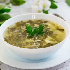 Zupa szczawiowa ze słoika przepis: aromatyczna, zielona zupa z dodatkiem jajka, udekorowana natką pietruszki.