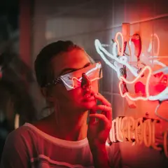 Dziewczyna w neonowych okularach przy świetlnej instalacji. Idealne miejsce, gdzie można potańczyć w Kołobrzegu, czeka na Ciebie!