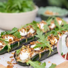 Grillad zucchini med krämig topping, nötter och ruccola. En man ler i en cirkel till höger.