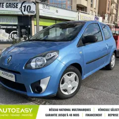 Une Twingo 2 phase 2 bleue, garée devant un commerce.