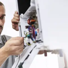 Fachowiec dokonuje przeglądu instalacji w urządzeniu, zapewniając sprawny **serwis Saunier Duval**.