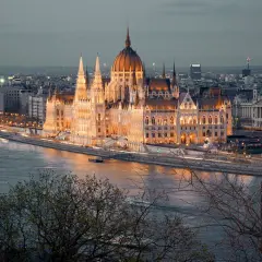 Wspaniały budynek Parlamentu, oświetlony nocą, góruje nad Dunajem. To serce stolicy Węgier, Budapesztu, tętniące życiem.