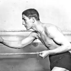 Georges Carpentier, a legendary boxer, poses in the ring, his muscular physique ready for action.