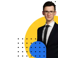 Mężczyzna w garniturze i okularach na tle żółtego koła i niebieskiego okręgu z kropkami.