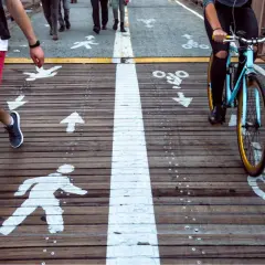 Osoba na rowerze jedzie po wyznaczonym pasie, zgodnie z art. 97 k.w. Jazda rowerem po chodniku jest zabroniona.