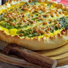Tarta ze szparagami i serem na kruchym cieście, obok nóż.