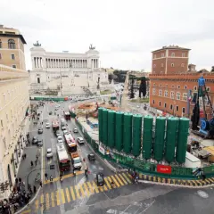 Vista aerea di Roma con il Vittoriano sullo sfondo e lavori in corso. Per capire come arrivare a Piazza Venezia, osserva il traffico e i palazzi storici.