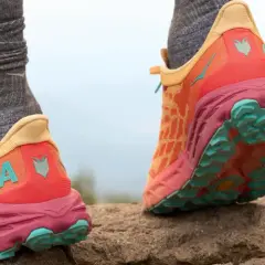 Kolorowe buty Hoka na kamienistym szlaku. Firma Hoka słynie z amortyzacji i innowacyjnych rozwiązań dla biegaczy.