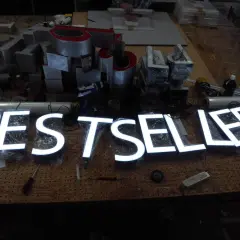Litery "BESTSELLER" świecące białym światłem, obok zasilacz. Czy 30w led ile to wat?