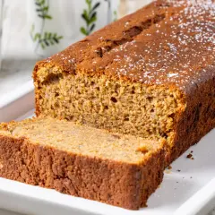 Fetta di banana bread light, soffice e dorata, cosparsa di zucchero a velo. Perfetta per una colazione sana.