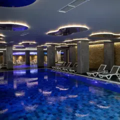 Nowoczesny basen w hotelu dla dorosłych w Polsce. Luksusowe leżaki i nastrojowe oświetlenie tworzą idealną atmosferę relaksu.