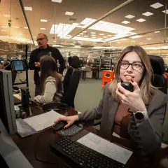 Kontroler ruchu lotniczego w akcji, monitoruje przestrzeń powietrzną i komunikuje się przez radio.