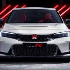 Blanco Honda Civic Type R CV con asientos rojos, listo para la acción bajo luces de neón rojas.