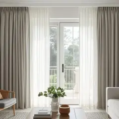 Elegant living room with floor-to-ceiling eyelet curtains framing a glass door, creating a soft, layered look.