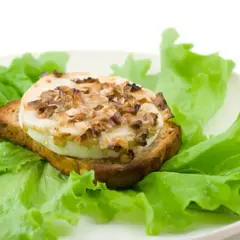 Tartine de chèvre chaud, garnie de noix, sur un lit de laitue fraîche. Un délice simple, comme un chevre au barbecue.
