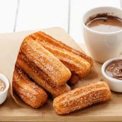 Churros dorés et croustillants, saupoudrés de sucre, prêts à être trempés dans le chocolat. Une recette gourmande pour un goûter parfait.