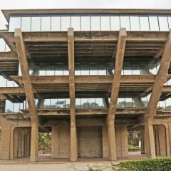 The Geisel Library, a famous brutalist architecture masterpiece, features stacked concrete levels with glass windows, resembling a Mayan pyramid.
