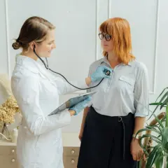 Lekarka bada pacjentkę stetoskopem, by ocenić, jak szybko rośnie guz w piersiach.