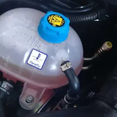 Depósito de expansión del refrigerante de un coche. El símbolo de termómetro y "Paraflu" indican el líquido anticongelante.
