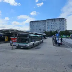 Autobus na przystanku przed budynkiem lotniska.