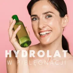 Uśmiechnięta kobieta trzyma buteleczkę z zielonym płynem. To hydrolat, który odświeża i nawilża skórę.