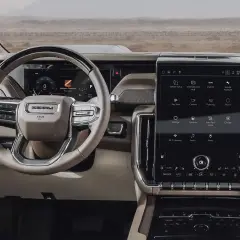 Wnętrze GMC Yukon XL z dużym ekranem dotykowym, kierownicą Denali i cyfrowymi wskaźnikami.