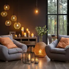 Dos sillones grises invitan al descanso junto a una chimenea de leña, creando una lámpara ambiente acogedora. Velas y luces cálidas iluminan la escena.