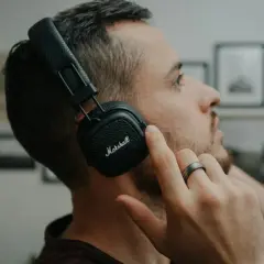 Mężczyzna w słuchawkach Marshall, skupiony na dźwiękach 432 hz.