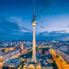 Fernsehturm reser sig över Berlins silhuett i skymningen. En perfekt vy för din berlin reseguide.