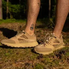 Beżowe buty trekkingowe z siateczkowaną cholewką buta, idealne na leśne wędrówki.