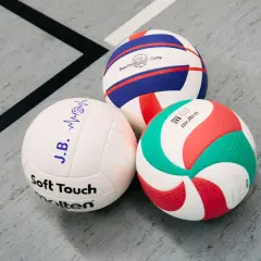 Trzy piłki siatkowe: biała z napisem "Soft Touch", biało-niebiesko-czerwona z napisem "Beachvolleyball Camp" i biało-zielono-czerwona Molten.