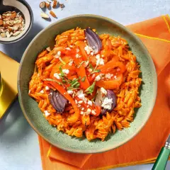 En skål med orzo pasta med rostade grönsaker, fetaost och mandlar. Ett perfekt medelhavskost recept för en lätt och smakrik måltid.